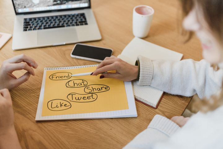 Personas organizando ideas de contenido junto a un portátil