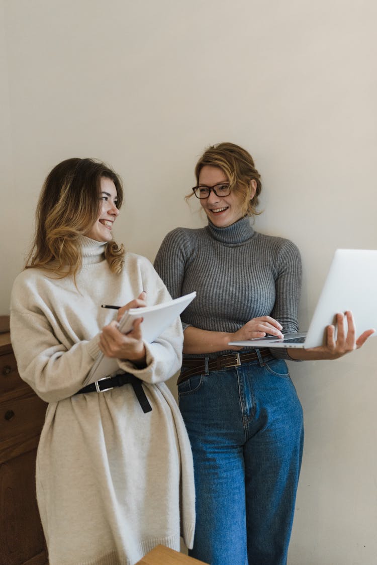 Smiling Women Working On Laptop Together