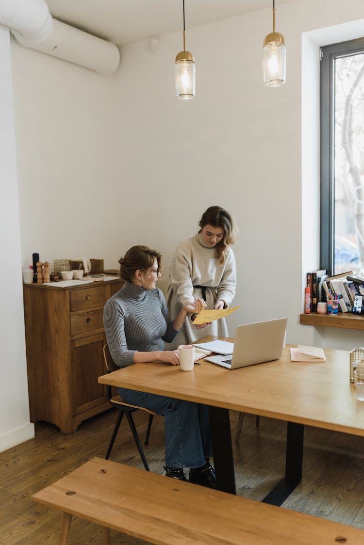 Women Communicating Working On Laptop In Office