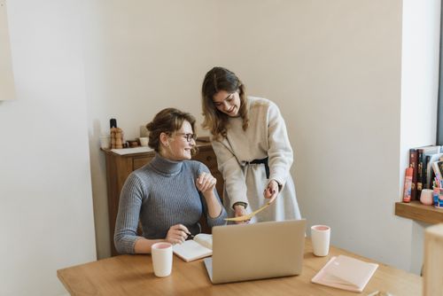 Free Two women discussing a project with a laptop in a bright modern office. Stock Photo