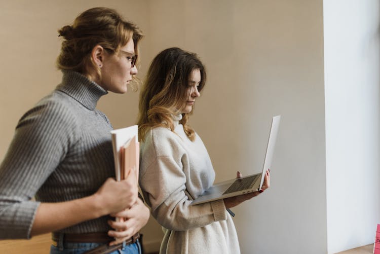 Women Standing Working On Laptop Together