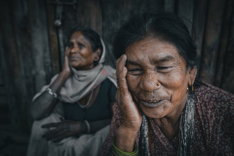 Cheerful Senior Indian Female Friends Touching Faces In Daytime