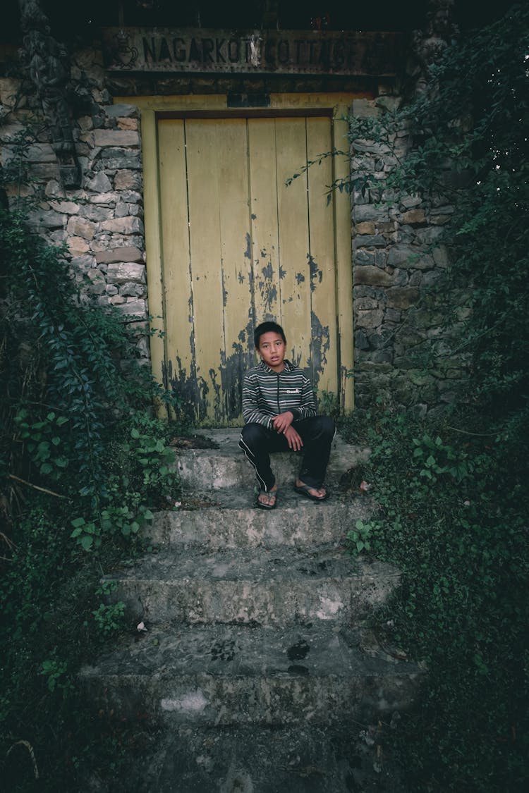 Ethnic Teen Resting On Stone Stairs Of Old House