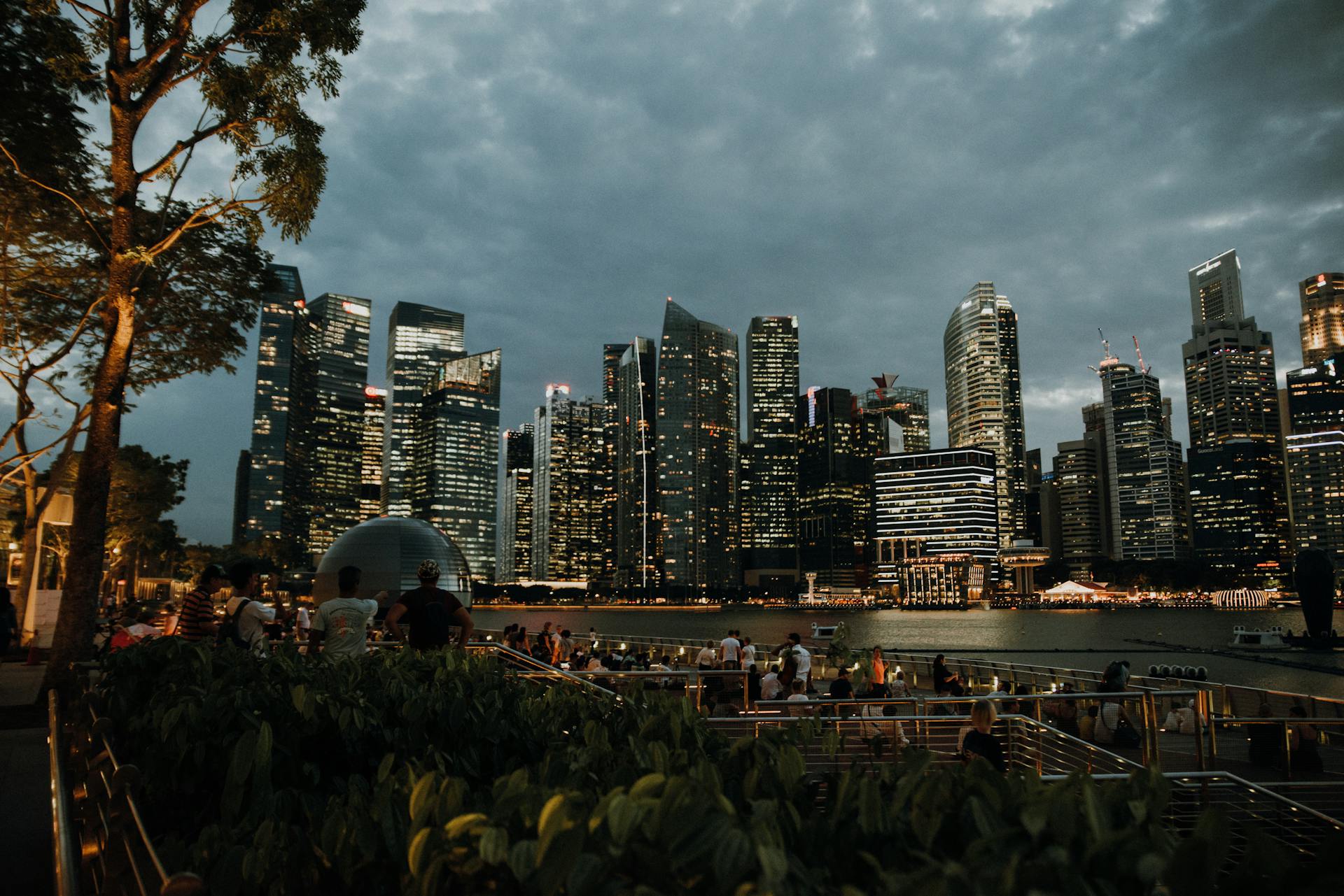 Captivating view of the Singapore skyline at twilight with city lights reflecting on the water.