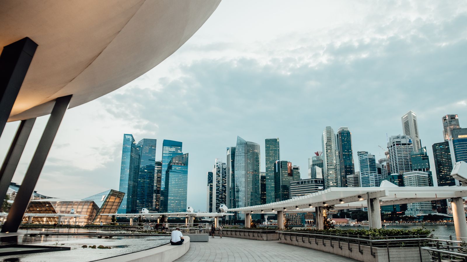 View of the iconic Singapore skyline and Marina Bay Sands from the promenade at twilight.