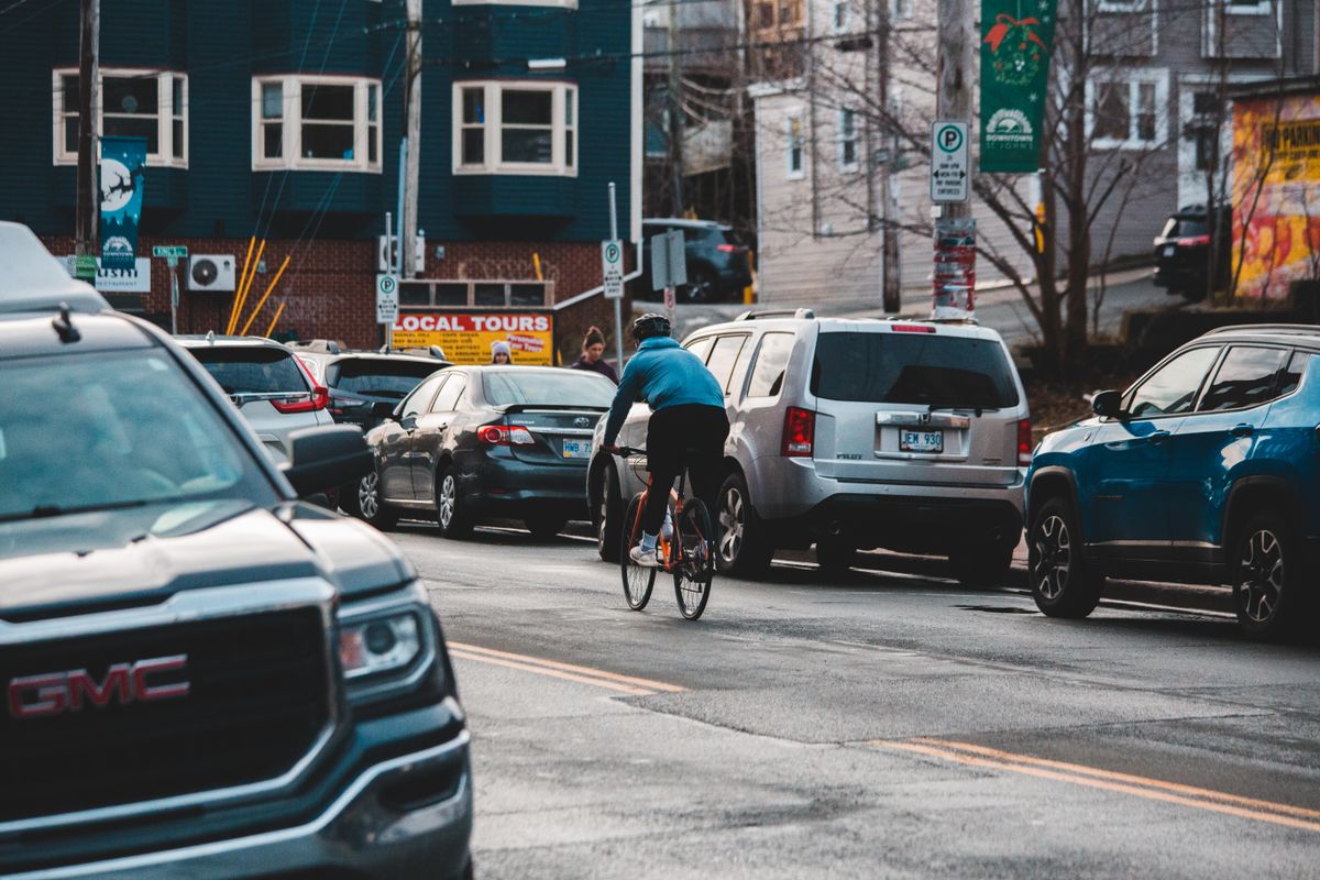 Cyclist riding through a city street surrounded by urban architecture