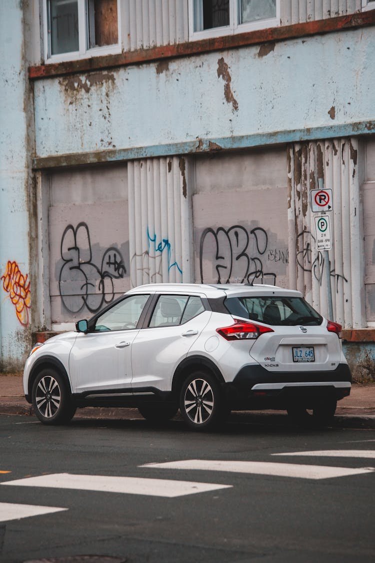 Expensive White Car Placed Near Wall Of Building On Street In Daytime