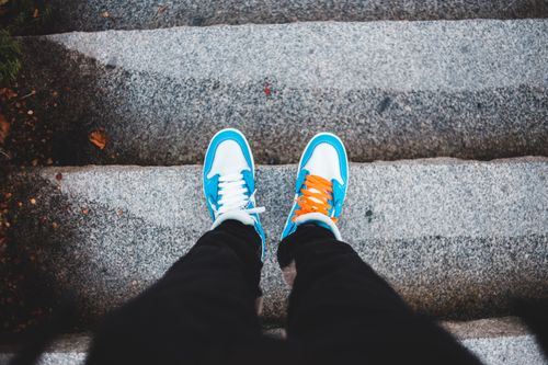 Free A top view of colorful sneakers standing on stone stairs, offering a unique perspective. Stock Photo