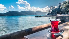 晴朗的天空下，湖边的桌子上放着一杯茶，可以欣赏到宁静的景色