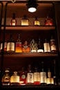 From below of interior of restaurant with bottles of different alcohol placed on shelves under bright illumination