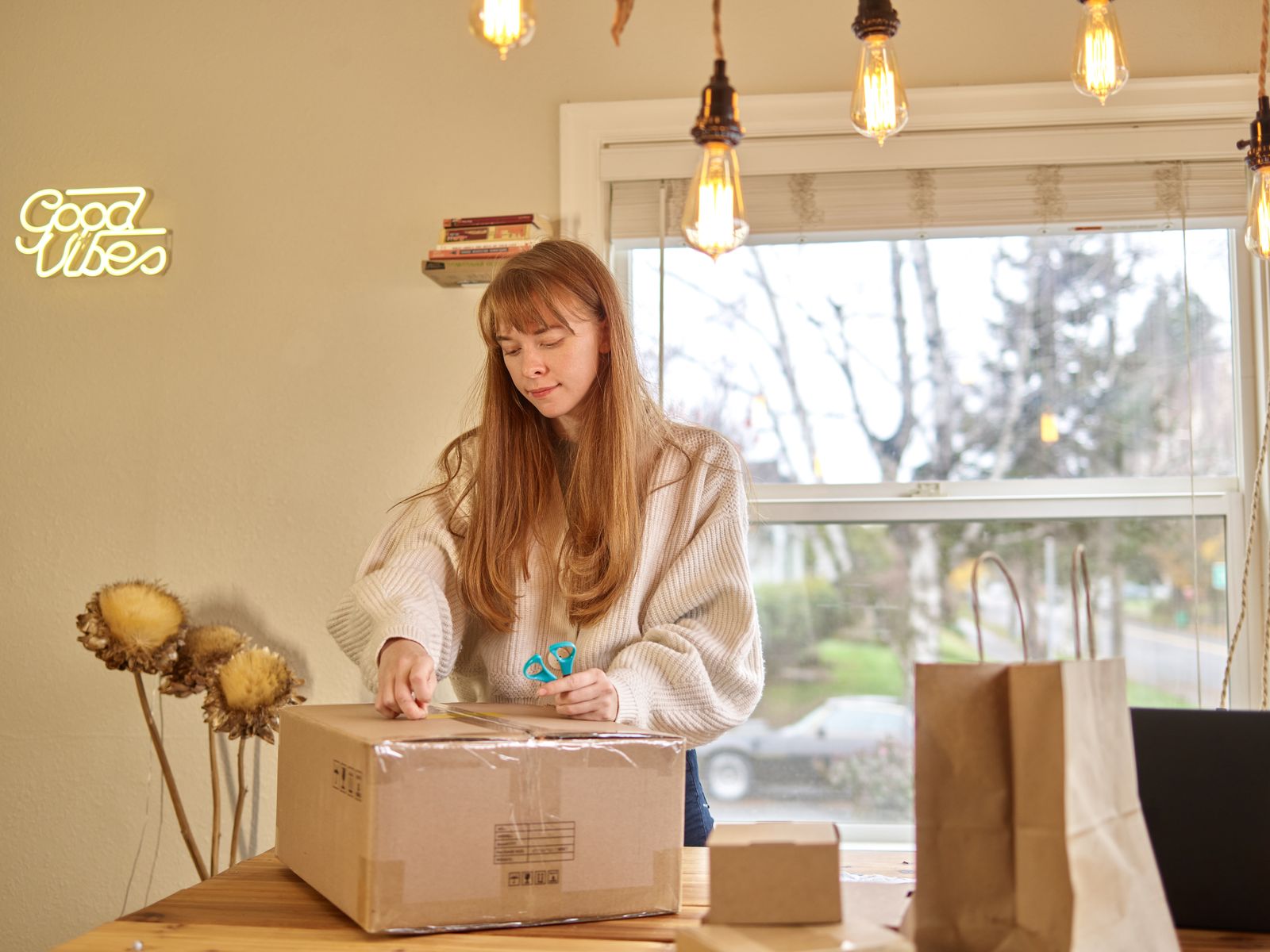Woman opening a parcel in a warm and refined home interior