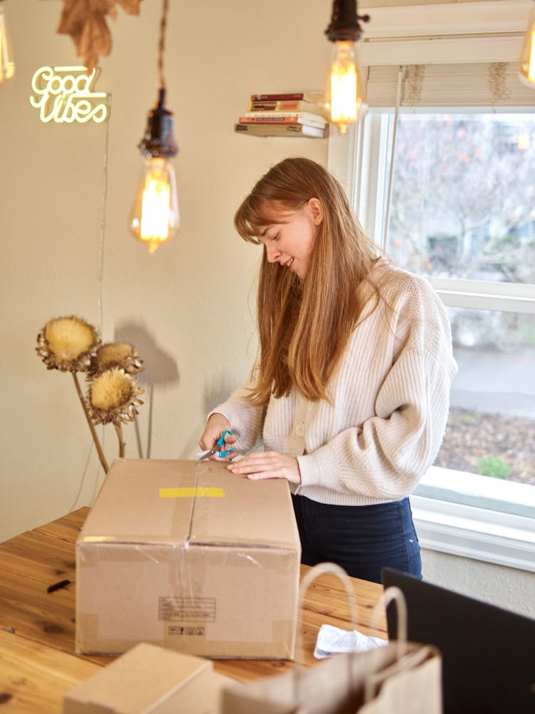 Woman Unboxing Package On Table