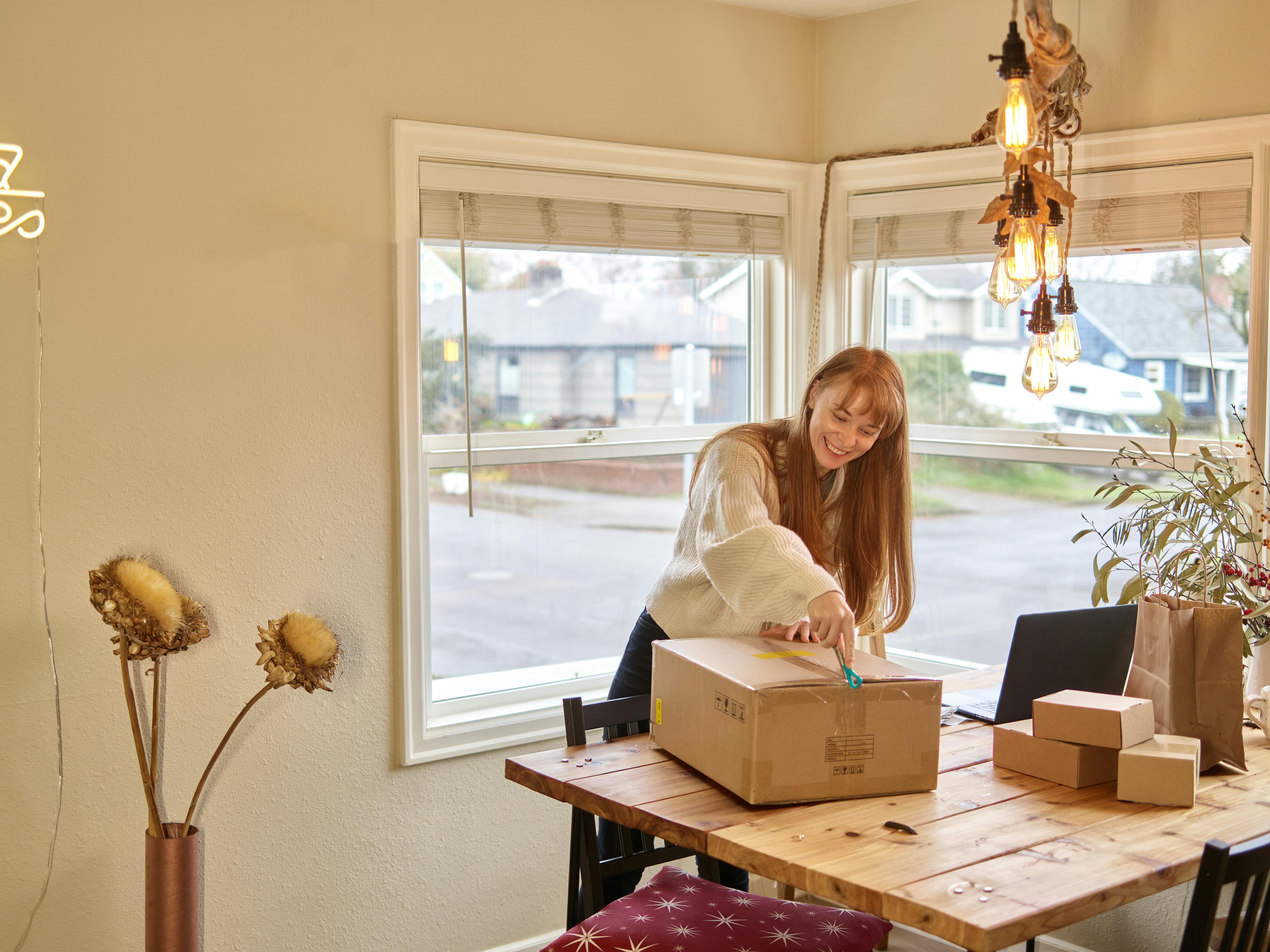 A shopper happily unboxing a package received from AliExpress.