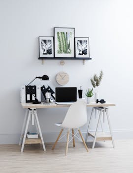 Elegant home office with minimalist decor, featuring a desk, chair, and plant.