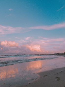 A peaceful beach scene at sunset with gentle waves and soft pastel skies.