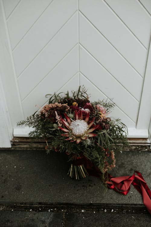 A Bouquet of Flowers Leaning on a White Wall