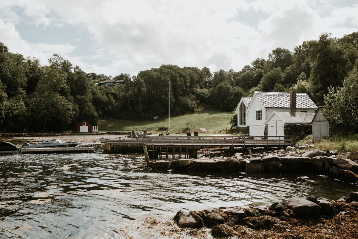 Serene lakeside scene with a dock, boats and lush greenery