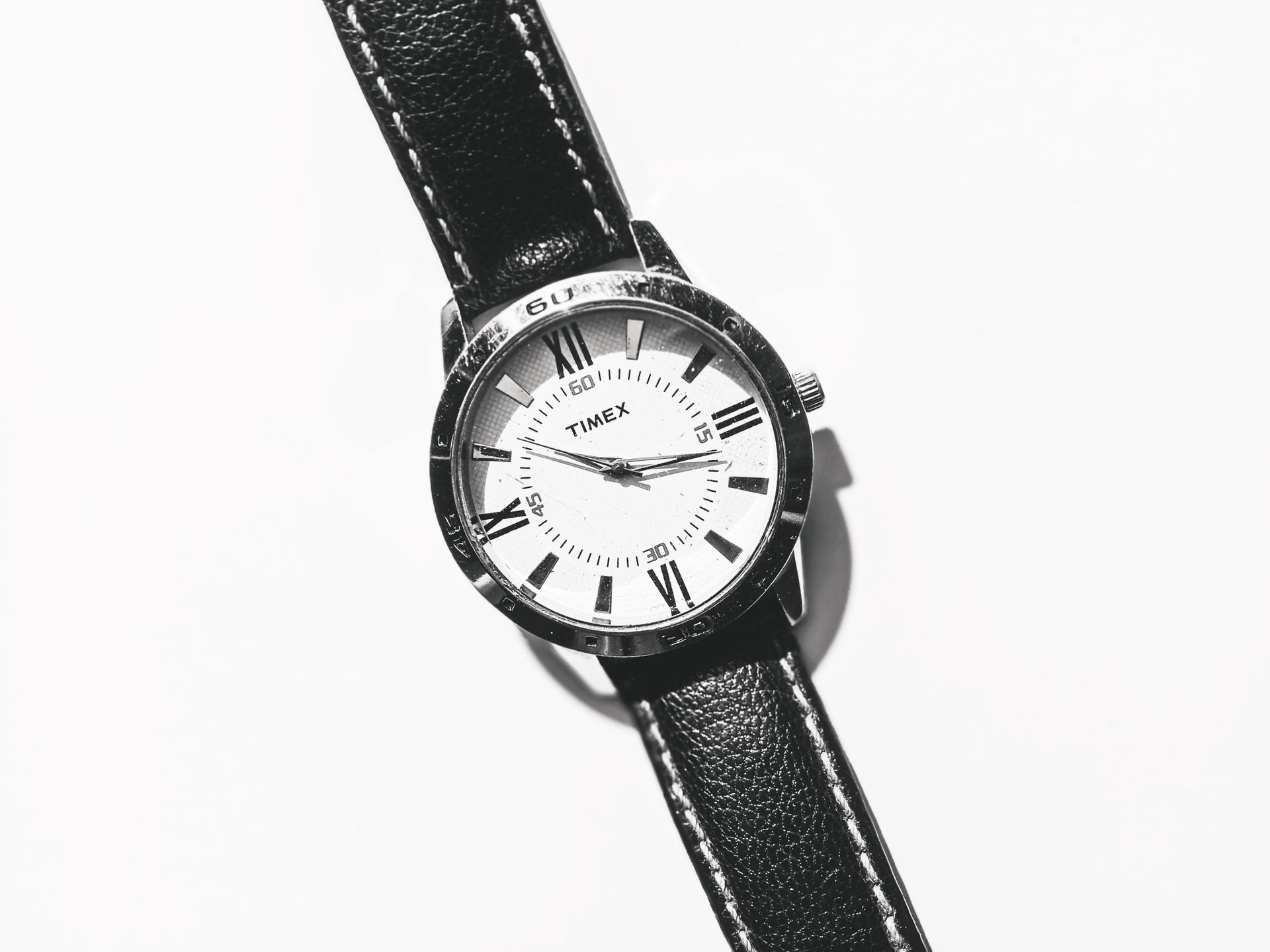 Close-up of a classic Timex wristwatch with black strap on a white background, showcasing elegance.