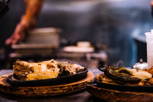 Hot Delicious Food on Sizzling Plates with Wooden Boards