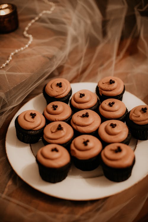 Delicious Creamy Cupcakes with Chocolate Beads on a White Plate