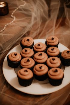Chocolate cupcakes with creamy icing on a plate, perfect for dessert lovers.