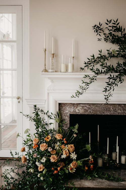 Free Beautiful Flower Set-up Near Fire Place with Lighted Candles Stock Photo