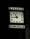 Black and White Analog Clock on a Dark Surface with Signs