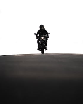 Silhouette of a motorcyclist riding on a quiet road in Los Angeles.