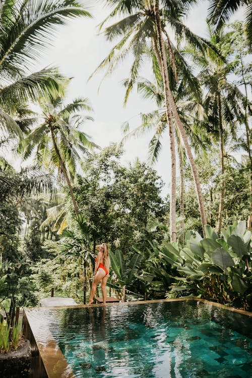 A Woman in Red Bikini Standing on the Pool Ledge