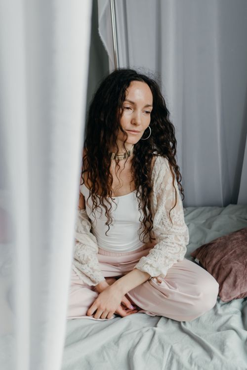 Free Serene woman practicing meditation on a bed, creating a calm and tranquil atmosphere. Stock Photo