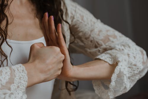 Mujer En Vestido De Encaje Blanco Sosteniendo Su Cabello