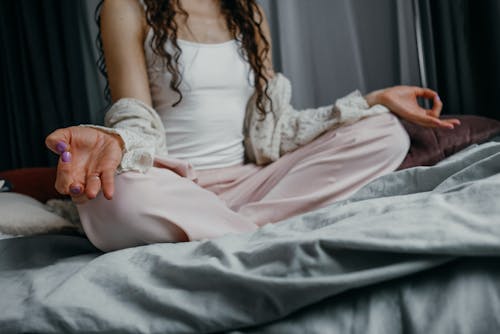 Frau Im Weißen Trägershirt Und Im Rosa Rock, Die Auf Bett Sitzen