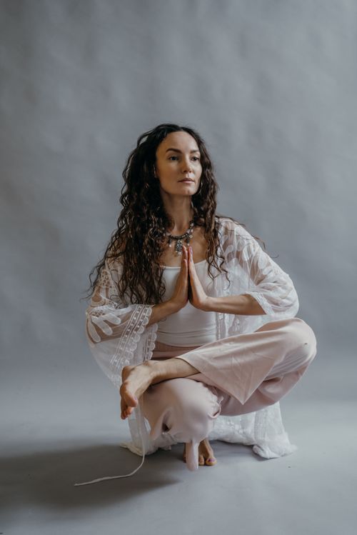Free Woman practicing meditation in a yoga pose while balancing indoors, dressed in casual attire. Stock Photo