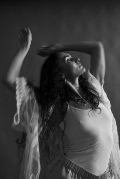 A graceful dancer striking a pose in black and white, exuding elegance and movement.