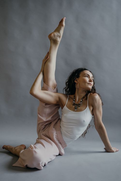 Free A woman stretches gracefully during a yoga session, showcasing flexibility and focus. Stock Photo