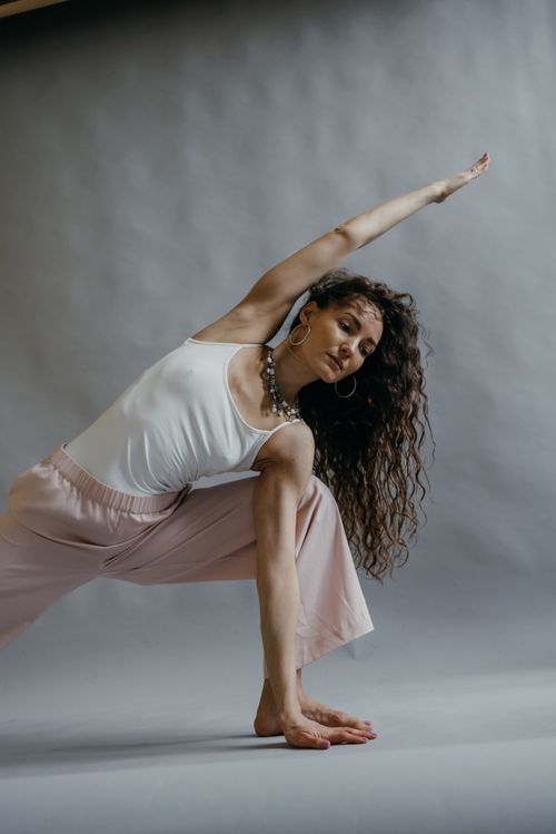 Free Graceful woman performing a yoga stretch indoors, embracing a healthy lifestyle. Stock Photo