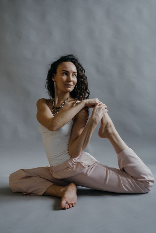 Free Woman stretching in a graceful yoga pose, focused on wellness and flexibility. Stock Photo