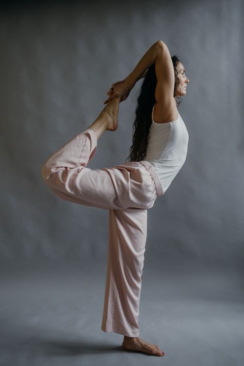 Free Woman in a graceful yoga pose indoors, showcasing flexibility and balance. Stock Photo