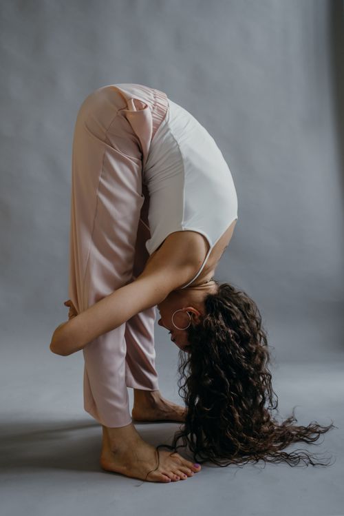 Free Young woman performing yoga pose indoors emphasizing flexibility and strength. Stock Photo