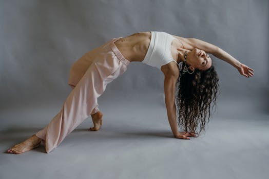 A woman practicing a graceful yoga pose indoors, showcasing flexibility and wellness.