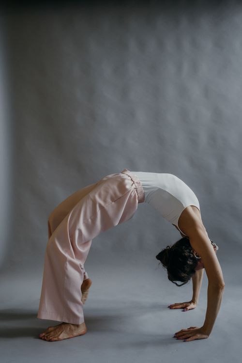 Free A woman in a studio performing a bridge pose symbolizes flexibility and mindfulness. Stock Photo
