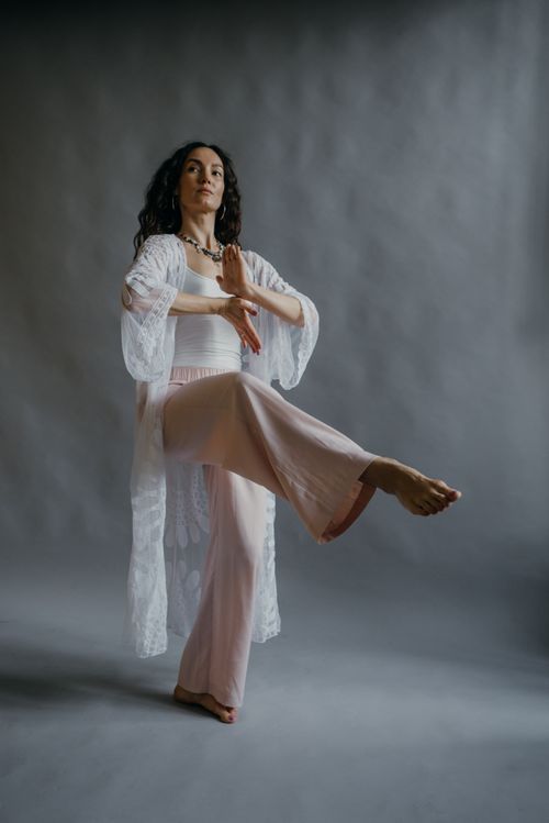 Free Woman in a white outfit performing yoga in a studio setting for relaxation and mindfulness. Stock Photo