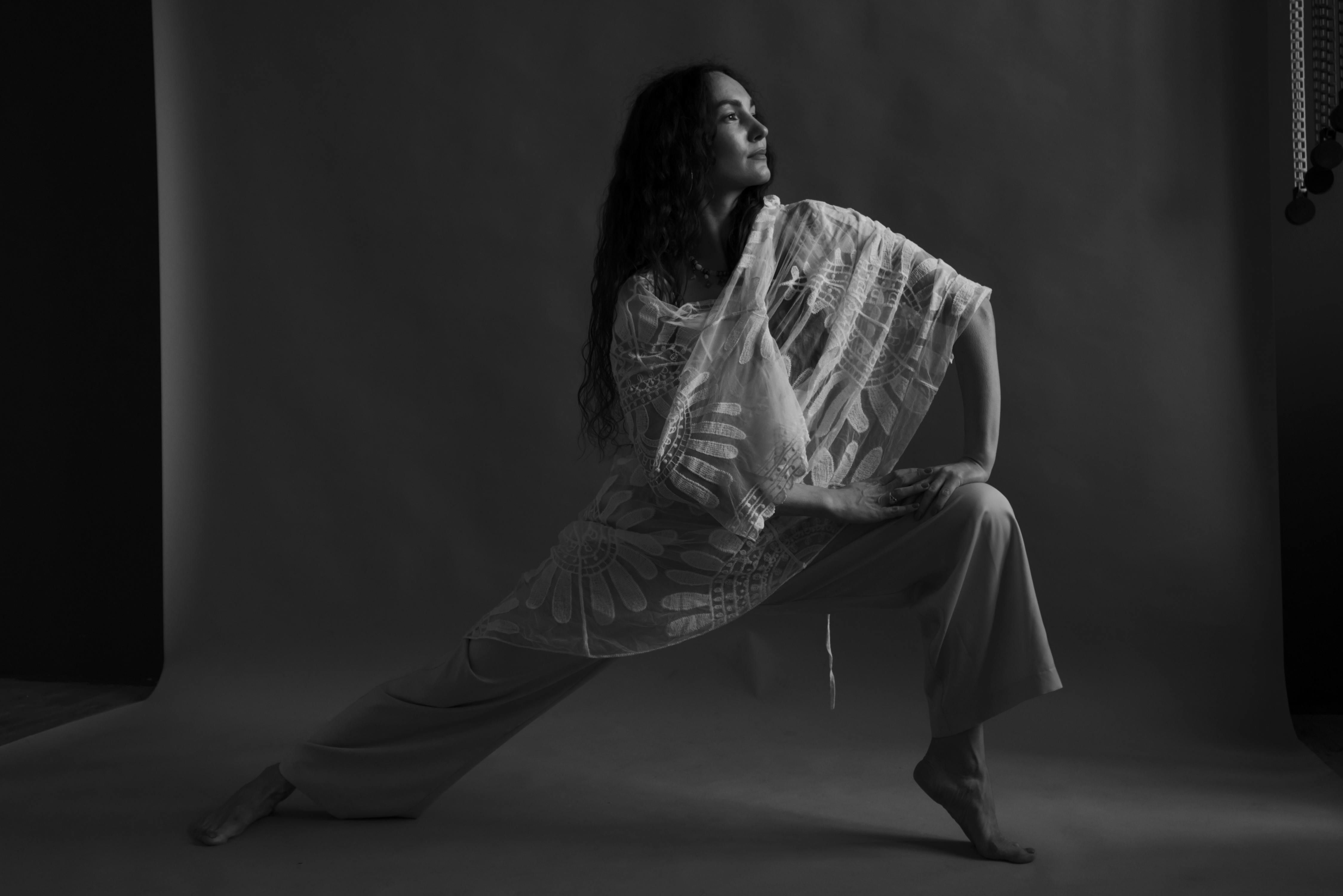Woman in White and Black Stripe Long Sleeve Shirt and White Pants Sitting on Floor