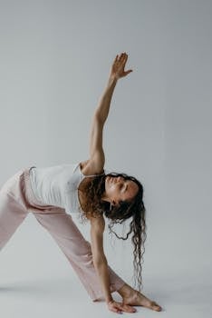 A woman doing a yoga pose in a minimalistic studio setting for wellness and relaxation.