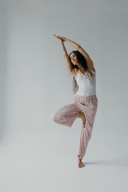 Free Woman practicing a serene yoga pose in a minimalist studio, embodying tranquility and balance. Stock Photo