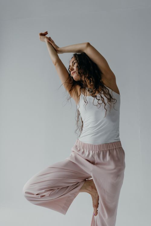 Free An adult woman gracefully performing a yoga pose indoors, focusing on balance and mindfulness. Stock Photo
