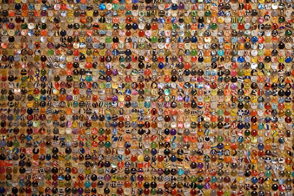 A vibrant assortment of multi-colored bottle caps pinned on a board, creating an artistic and textured visual display.