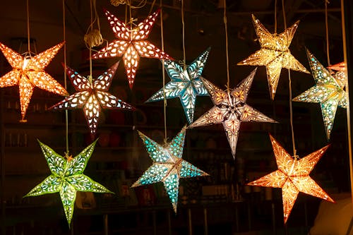 Free Christmas Star Lanterns with Various Designs Hanging from Ropes Stock Photo