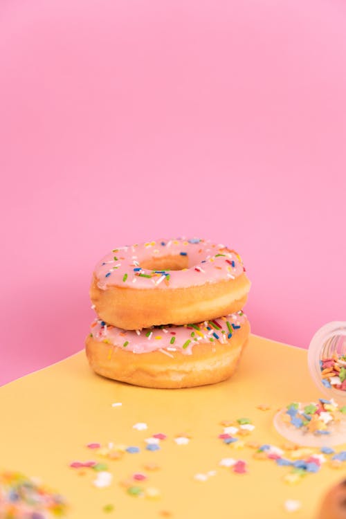 Delicious Doughnuts with Sprinkles on Yellow Surface