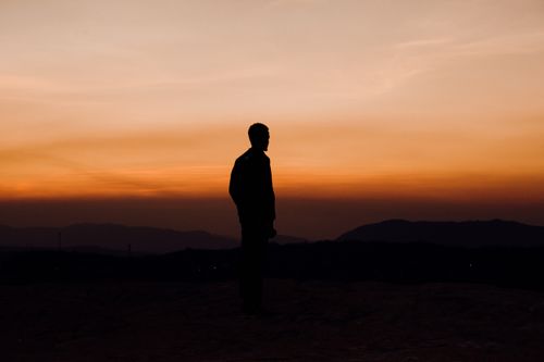 Free Silhouette of a man standing against a dramatic sunset in Iringa, Tanzania. Stock Photo